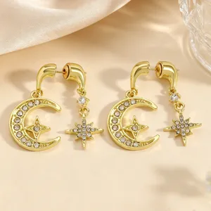 Close-up detail van vergulde halve maan en ster strass oorknopjes voor dames.