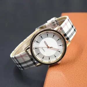Gros plan d'une montre quartz pour femme avec bracelet en tissu écossais et boîtier or rose.