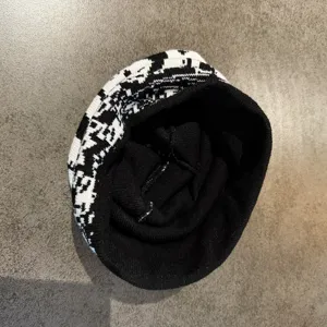 Nahaufnahme der schwarz-weißen Jacquard-Strickmütze mit feiner Mustertextur und Detail.