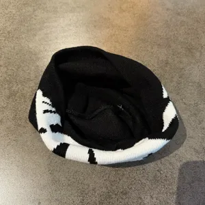 Black and white knitted beanie hat, trendy streetwear short skull cap for autumn and winter.
