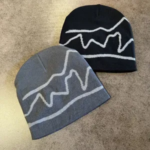 Vista dettagliata dei berretti in maglia con motivo ad onda retro americana in nero e grigio inverno.
