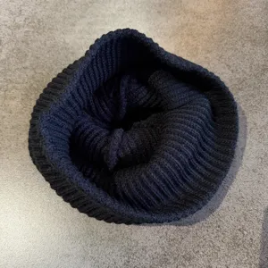 Detailansicht einer einfarbigen schwarzen Strickmütze, dick, thermisch, gerippt, Streetwear.