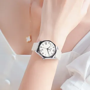 Detailed close-up of a minimalist quartz watch with a white dial, canvas strap, and clear numerals.
