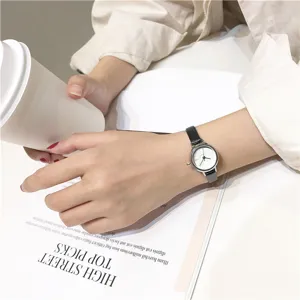 Minimalistisch klein rond quartz horloge met zwarte lederen band voor vrouwen mode detail.