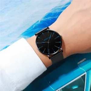 Detailaufnahme einer schwarzen Quarzuhr mit blauen Indizes und Armband am Handgelenk.