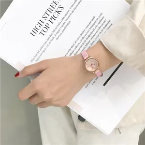 Detailopname van een minimalistisch dameskwartshorloge met roze lederen band en ronde wijzerplaat.