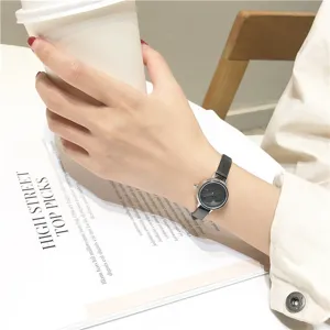 Minimalistisch quartz horloge met zwart leren bandje voor dames elegante pols detail weergave.