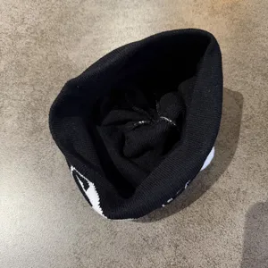 Detailansicht der schwarzen Strickmütze mit Einblick in die Innenverarbeitung.