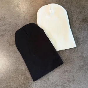 Modieuze winter gebreide muts beanie met metalen spelddecoratie in zwart en witkleur