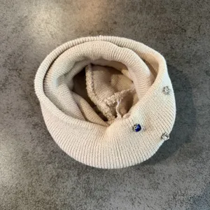 Close-up van beige gebreide muts gedetailleerd met sprankelende strass spelden voor herfst winter.