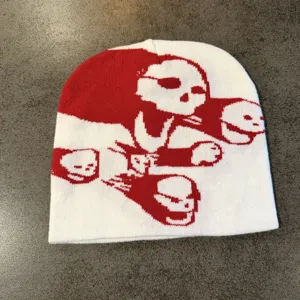 Strickmütze Detail, rot-weißes Totenkopf Muster, Streetwear Winter warme Mütze Nahaufnahme.