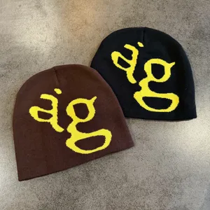 Gedetailleerd overzicht van gebreide mutsen in bruin en zwart met opvallend geel gebreid letterdesign.