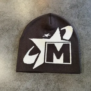 Vista detallada de un gorro de punto de invierno elegante con diseño jacquard de estrella y M.