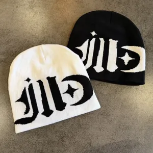 Black and white colorblock knit beanie with gothic style woven letters and star design.
