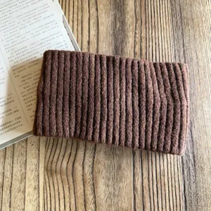 Close-up detail view of a cozy brown knit headband, wide winter warm hair accessory.
