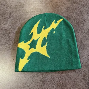 Grüne Strickmütze Detailansicht, gemütliche Winter Streetwear Beanie mit gelbem Motiv.