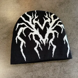 Gros plan detaille du bonnet en tricot noir avec motif de toile d'araignee gothique.