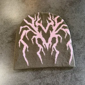 Bonnet en tricot vue de détail montrant motif jacquard toile d'araignée cœur rose kaki.