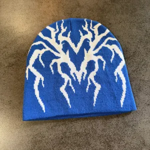 Bonnet en tricot bleu avec motif jacquard toile d'araignée blanche, bonnet chaud et stylé.