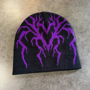 Gros plan sur le bonnet en tricot noir avec motif jacquard toile d'araignée violet.