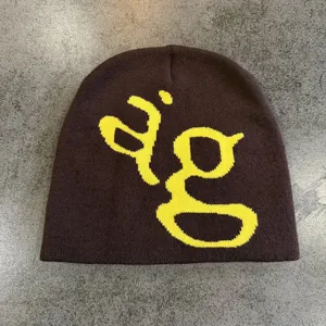 Gedetailleerd uitzicht van de bruine gebreide muts met geel letter grafisch ontwerp voor de winter.