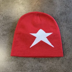 Red knitted beanie featuring a large white star jacquard pattern, warm winter streetwear hat.