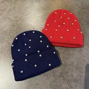Detail view of stylish rhinestone knit beanies in blue and red, perfect warm winter hats.