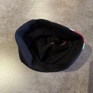 Gedetailleerd uitzicht op de binnenkant van de zwarte gebreide muts met zachte textuur.