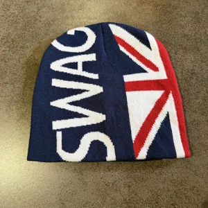 Detailopname van een gebreide muts met Britse vlag en SWAG-motief, lekker warm en comfortabel.
