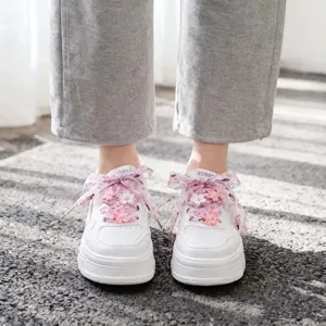 White casual sneakers with pink floral organza ribbon laces and cute flower charms.