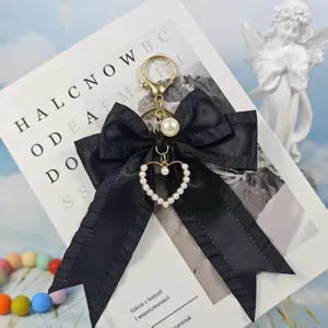 Black pleated ribbon bow keychain with pearl heart pendant for women bag and car keys.