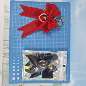 Pleated ribbon bow keychain with pearl heart charm for women bags and car keys details.
