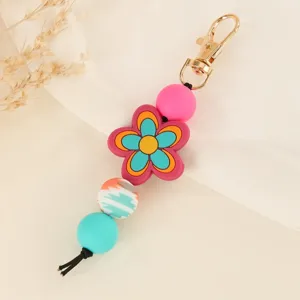 Colorful silicone flower bead keychain bag charm, handmade DIY accessory closeup detail view.