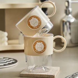 Gobelet de rince-bouche en plastique transparent avec motif d'ours mignon et poignée beige.