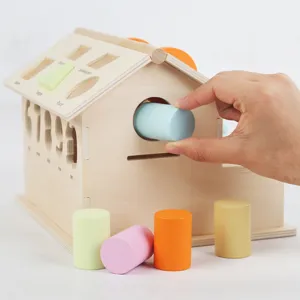 Casa giocattolo in legno per smistamento forme con blocchi cilindrici per bambini.