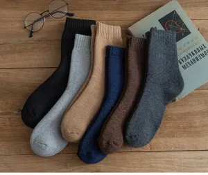 Detailansicht dicker Wintersocken, kuschelige Thermosocken auf Holzgrundlage präsentiert.