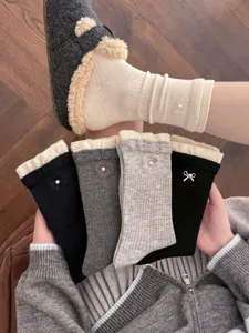 Detail view of Korean style cashmere blend socks featuring cute pearl bows and cozy ribbed cuffs.