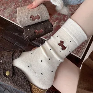Close-up detail of women winter cozy cashmere socks featuring cute dachshund embroidery and polka dots.