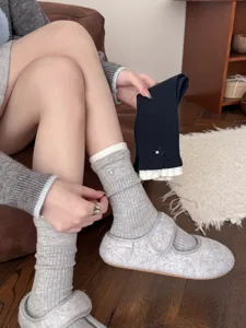Detailed view of women's cozy knit mid-tube socks featuring cute pearl bow and contrast cuff.