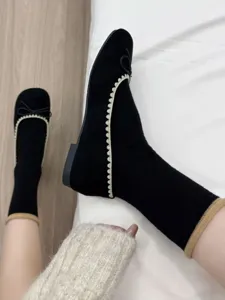 Scarpe basse nere da donna abbinate a comodi calzini, perfetto dettaglio di stile quotidiano.