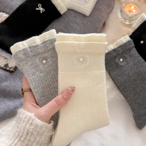 Detailed closeup of cozy women winter cashmere socks with elegant pearl bow accents.
