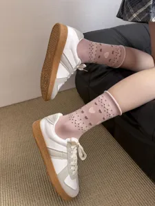 Retro pink mid-calf cotton socks featuring heart and bow patterns, paired with stylish casual sneakers.