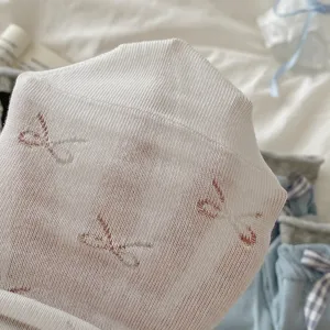 Λεπτομέρεια από λευκές διαφανείς κάλτσες πλεκτές με φιόγκους, γυναικείες καλοκαιρινές.