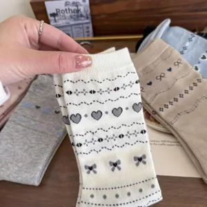 Detailed close-up of retro Fair Isle heart and bow knit socks texture, Korean college style cotton.