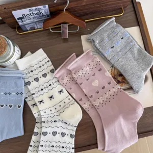 Detail shot of retro Fair Isle knit socks with cute heart and bow patterns in soft cotton.