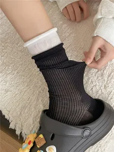 Detailed view of ultra-thin mid-calf socks with black and white color block and stretch fabric.