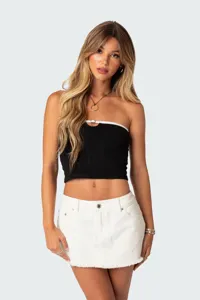 Gedetailleerde opname van zwarte strapless crop top met witte rand en ring.