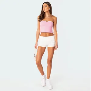 Volledige weergave van een stijlvolle roze strapless crop top met mooie witte shorts.