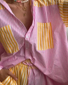 Detailed view of pink and yellow striped button-down shirt and shorts lounge set.