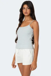 Close-up details of women casual striped camisole and white shorts, soft ribbed summer outfit.